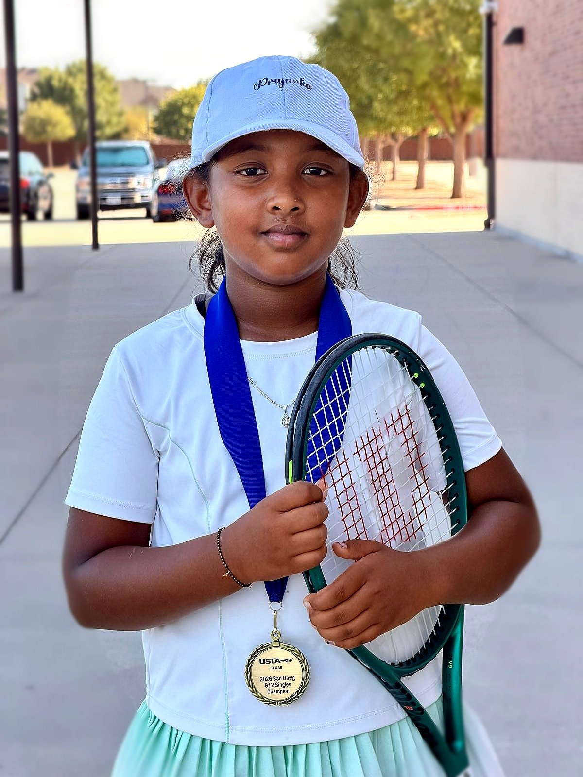 Priyanka holding her racquet and gold medal after winning Bad Dawg FRISCO